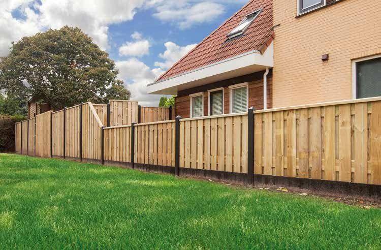 Lange houten schutting langs grasveld geplaatst door Franke Tuinen